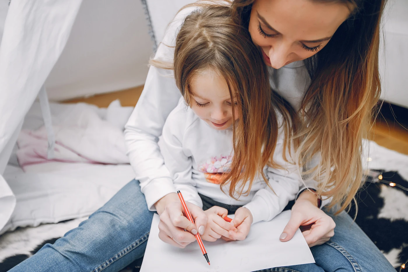 Mother with little daughter journaling at home